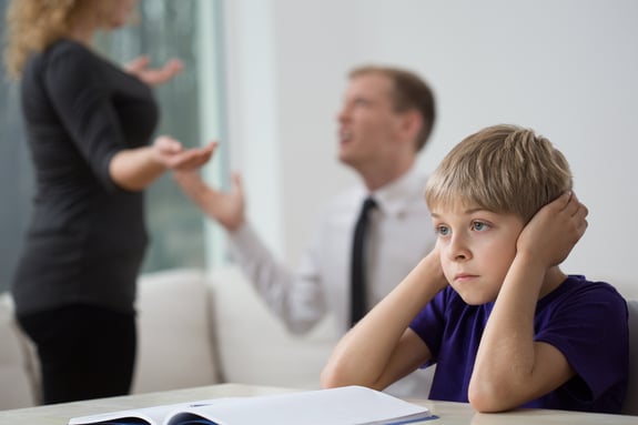 Sad little boy and family fight in living room